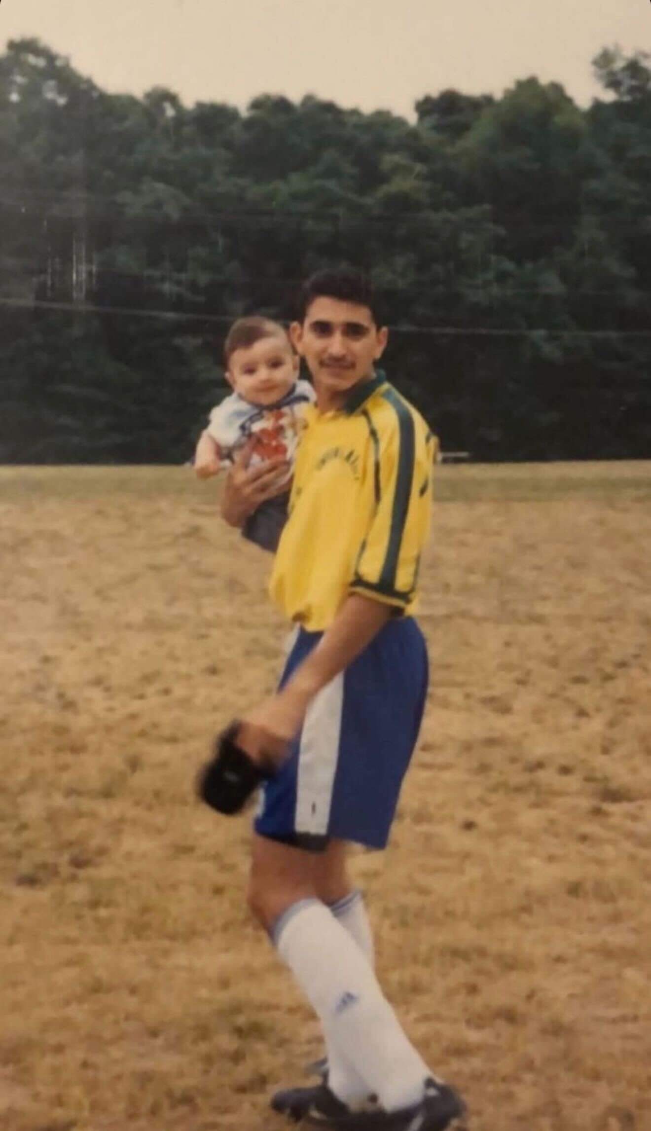Angel holding his son beside a playing field